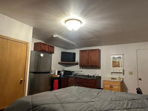 a small kitchen with a bed and a refrigerator at Bear Paw Inn 