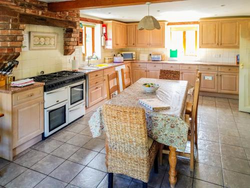 a kitchen with a table and a stove top oven at Howards End in Leysters