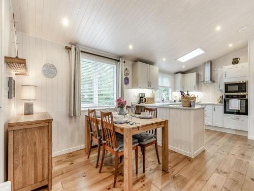 a kitchen with a wooden table and chairs at Rosemary Lodge in Willington