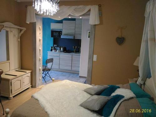 a bedroom with a large bed and a kitchen at Villa Lescala in Blaye
