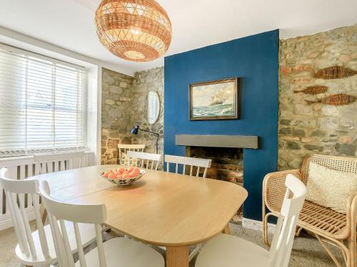 a dining room with a wooden table and chairs at Samphire Cottage in Lyme Regis