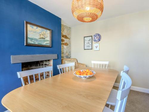 a dining room with a table and a bowl of fruit on it at Samphire Cottage in Lyme Regis