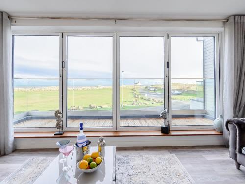 Zimmer mit einem Fenster und einer Schale mit Obst auf einem Tisch in der Unterkunft Coastal Retreat in Amble
