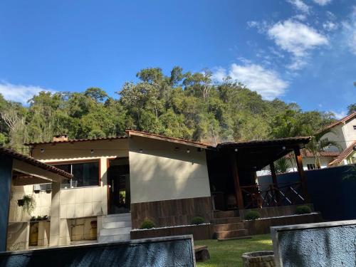 una casa con una montaña al fondo en Casa de Campo Cantinho da Mata, en Domingos Martins