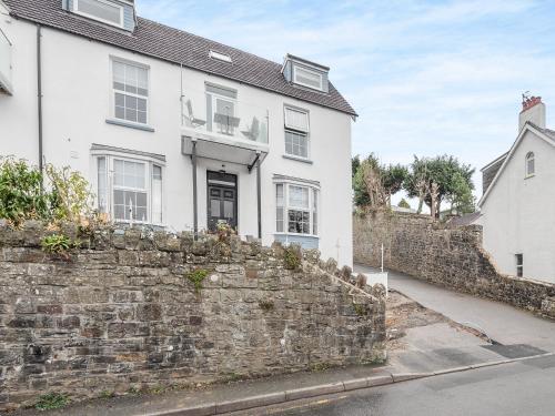 a white house with a stone wall at Sandy View - Uk43056 in Saundersfoot
