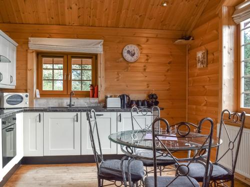 a kitchen with a table and chairs in a cabin at Bluebell -Uk48309 in Staintondale