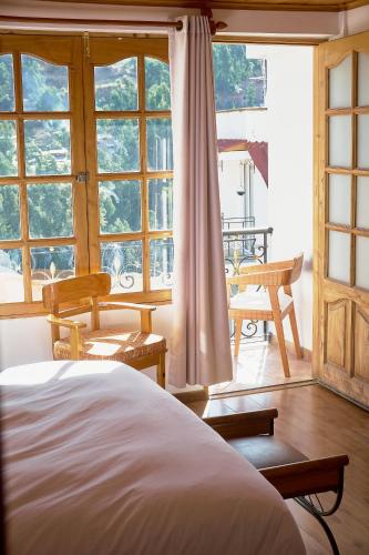 a bedroom with a bed and a large window at Maimara Hotel in Huaraz
