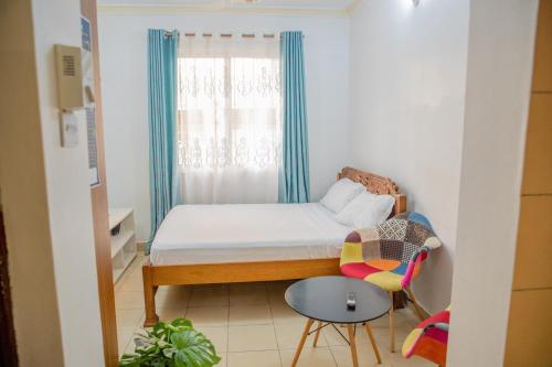a small bedroom with a bed and a window at Serene Apartments - studio 001 in Mombasa