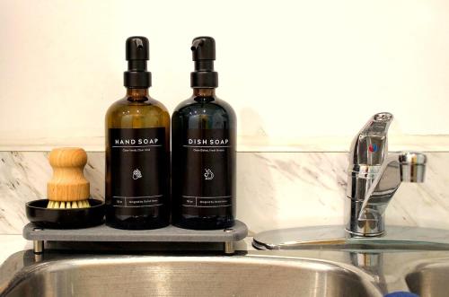 Cozy Bachelor Suite with Kitchenette - Near Downtown في سودبيري: زجاجتان من النبيذ تقعان فوق الحوض