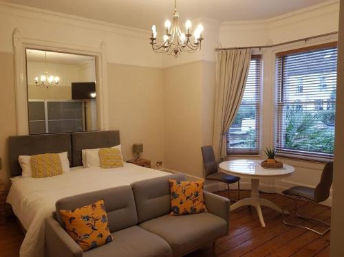 a bedroom with a bed and a couch and a table at The Residence in Norwich