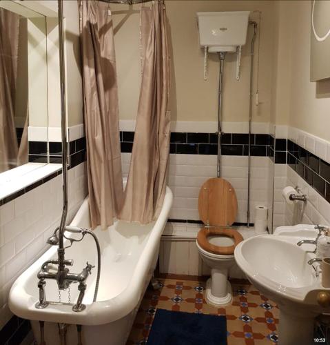 a bathroom with a tub and a toilet and a sink at The Residence in Norwich