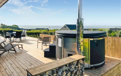 una parrilla en una terraza con mesa y sillas en 3 Bedroom Stunning Home In Øster Assels, en Øster Assels