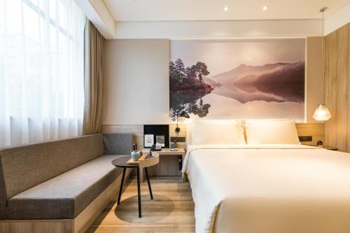 a hotel room with a bed and a bench at Atour Hotel Guangzhou Huadu Square in Huadu