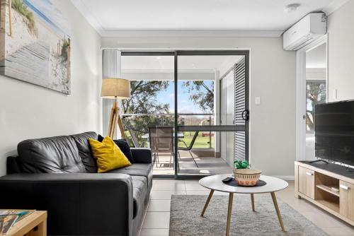 a living room with a couch and a table at Stylish Rockingham Getaway 2BR Coastal Apartment in Rockingham