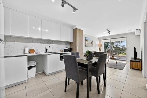 a kitchen and dining room with a table and chairs at Stylish Rockingham Getaway 2BR Coastal Apartment in Rockingham