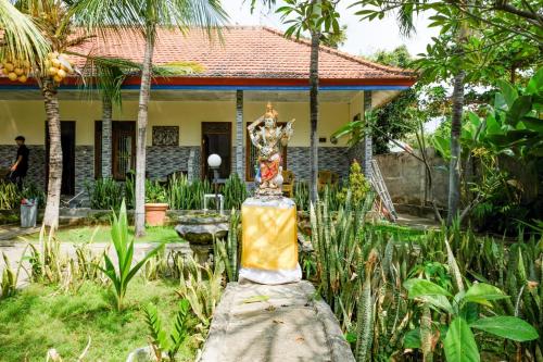 a garden with a statue in front of a house at RedDoorz Plus @ Singaraja in Singaraja