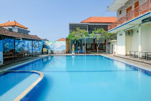 a large blue swimming pool in a building at RedDoorz Plus @ Singaraja in Singaraja