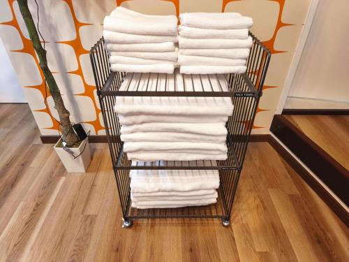 a rack of white towels in a store at simasimaｰstay高松駅フロント in Takamatsu