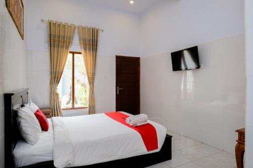 a bedroom with a bed and a window at RedDoorz Plus @ Singaraja in Singaraja