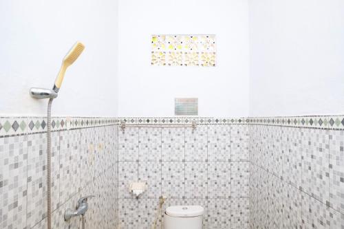 a bathroom with a toilet and a shower at RedDoorz Plus @ Singaraja in Singaraja
