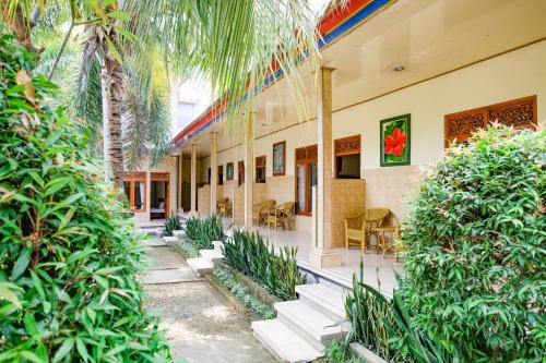 a building with a courtyard with palm trees at RedDoorz Plus @ Singaraja in Singaraja