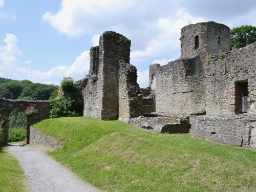an old castle on a hill with a dirt road at Dinhope Big Barn in Craven Arms