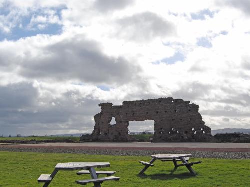 two picnic tables in front of a stone building at Dinhope Big Barn in Craven Arms