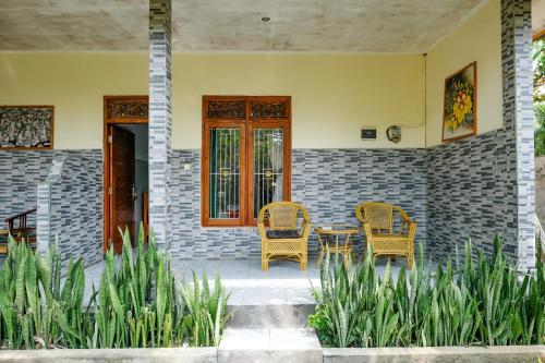 a patio with two chairs and a table on a house at RedDoorz Plus @ Singaraja in Singaraja