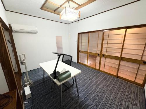 a room with a white table and a sliding door at 自然に囲まれた海沿いの広い一軒家 貸切 佐渡 古民家 レッドジャスパーRedjasper in Sado