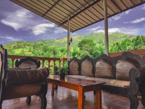 a living room with a couch and a table on a porch at View Paradise in Ella