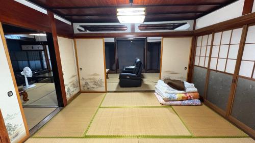 a view of a room with a chair and a couch at 自然に囲まれた海沿いの広い一軒家 貸切 佐渡 古民家 レッドジャスパーRedjasper in Sado