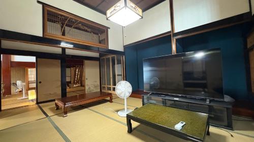 a living room with a large flat screen tv at 自然に囲まれた海沿いの広い一軒家 貸切 佐渡 古民家 レッドジャスパーRedjasper in Sado