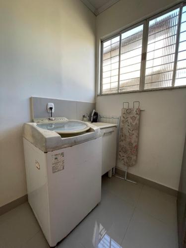 a bathroom with a sink and a washing machine at Apartamento próximo ao Hangar - COP 30 in Belém