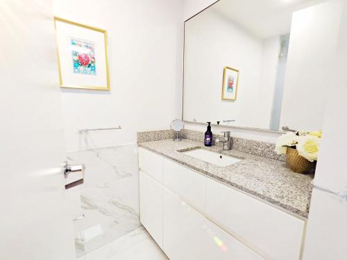 a white bathroom with a sink and a mirror at Leonora 2 MaiaHomeUbicacion Privilegiada 4BR 3BA en Polanco in Mexico City