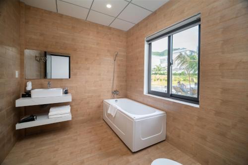 un bagno con una vasca bianca e un lavandino di La Costa Resort Quy Nhon a Quy Nhon