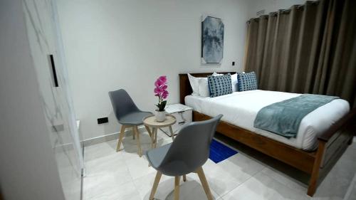 MchinjiにあるMMK Lodgeのベッドルーム1室(ベッド1台、椅子2脚、テーブル付)