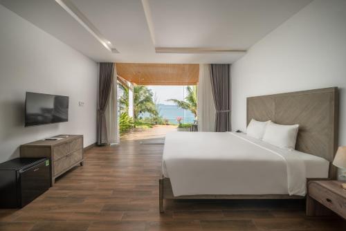 una camera da letto con un letto grande e una televisione di La Costa Resort Quy Nhon a Quy Nhon