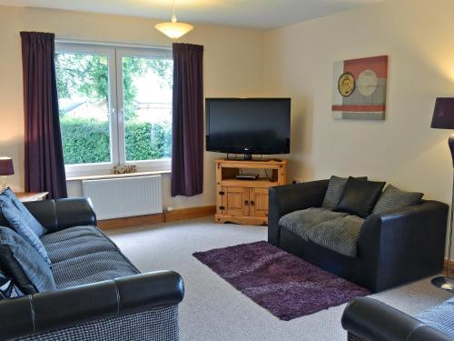 a living room with two couches and a flat screen tv at Cressfield Villa in Ecclefechan