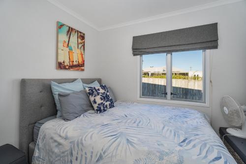 a bedroom with a bed with a window and a bed sidx sidx sidx at OCEA223A - Ocean Oasis in Whangamata