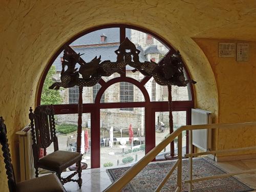 an arched window in a building with a chair in front at Hotel La Barakka in Lokeren