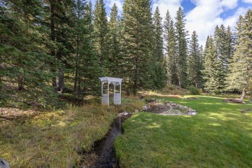 a sign in a field next to a stream at Ponderosa Hideaway-ATV, Hiking, Snowmobiling, Hunting & Casino Fun in Deadwood
