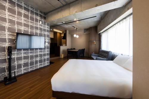 a bedroom with a large bed and a tv at Amp Flat Arc Bliss 4 in Chikushino
