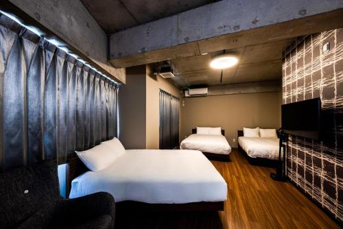 a room with two beds and a tv in it at Amp Flat Arc Bliss 4 in Chikushino