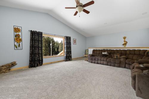 a living room with a couch and a ceiling fan at Ponderosa Hideaway-ATV, Hiking, Snowmobiling, Hunting & Casino Fun in Deadwood