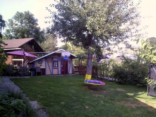 a tree swing in the yard of a house at Wannenhof Romantik in Bernau im Schwarzwald