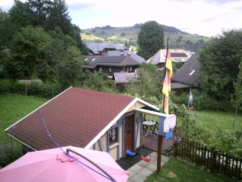 a small house with a roof and a pink umbrella at Wannenhof Romantik in Bernau im Schwarzwald