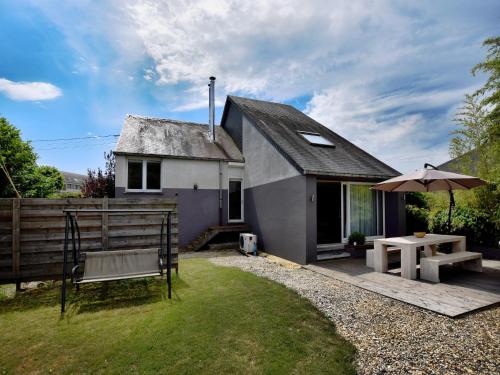 a small house with a bench and an umbrella at Holiday Home in Virton with swimming pool in Virton