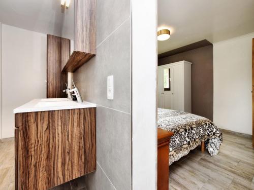 a bathroom with a sink and a bed in a room at Holiday Home in Virton with swimming pool in Virton