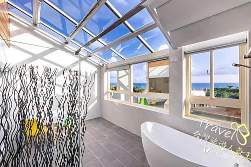 baño con bañera y techo de cristal en 墾丁卿卿文旅, en Hengchun