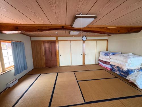a room with a bed and a clock on the ceiling at 自然に囲まれた海沿いの広い一軒家 貸切 佐渡 古民家 レッドジャスパーRedjasper in Sado